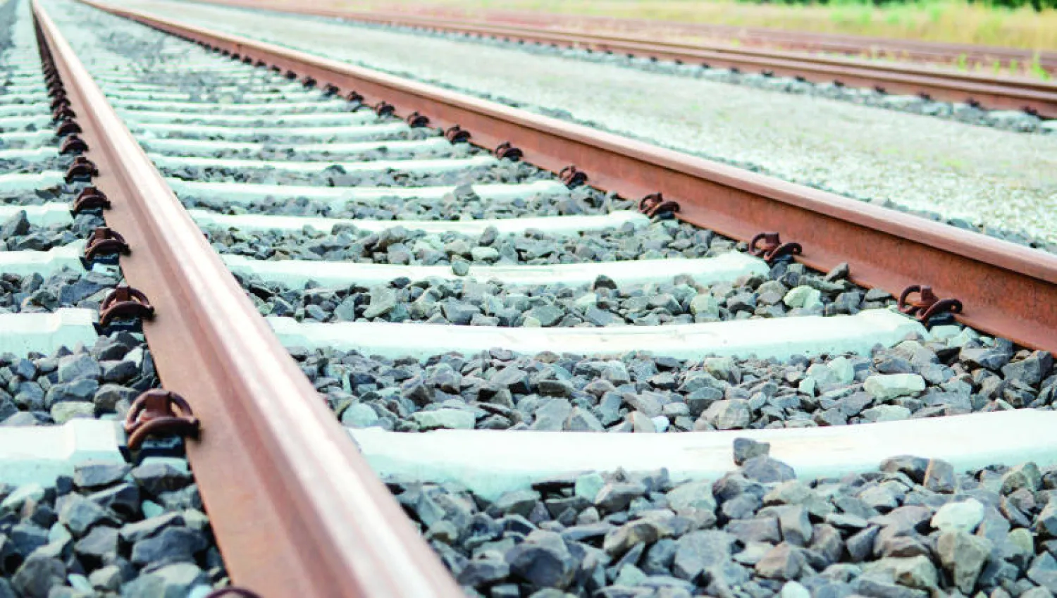 Hassad - Railjpg - Center News Network Two parallel railroad tracks run across a gravel bed, fading into the distance.