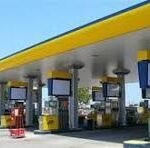 CNPC gas station with several fuel pumps beneath a yellow canopy on a sunny day.