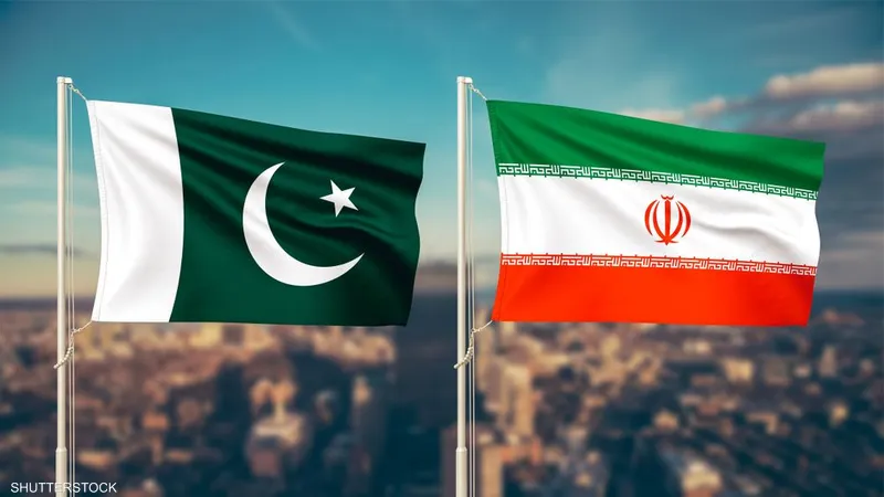 Two national flags on flagpoles flutter over a city skyline: Pakistan (green with crescent and star) and Iran (green, white, red).