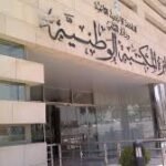 Front entrance of a modern building with Arabic signage and 'CNP' on the facade above the doors.