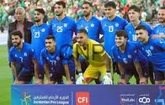 Soccer team in blue jerseys posing for a pre-match group photo on the field; goalkeeper wearing yellow stands in the center.