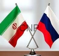 Crossed Iranian and Russian flags on a desk stand, symbolizing diplomatic relations.