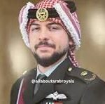 Portrait of a man with a beard wearing a red-and-white checkered turban and a formal military uniform with medals.