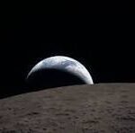Earthrise over the Moon's cratered surface, with Earth peeking above the lunar horizon.