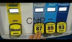 stat - Center News Network Gas pump with Diesel yellow nozzle on left and blue Regular/Plus/Premium nozzles; price tags show 87, 89, 93, with a hand nearby.