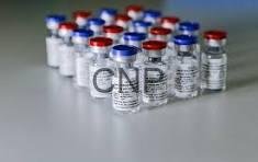 vax - Center News Network Row of small glass vials with red and blue caps lined up on a sterile lab surface, likely vaccines or medications.