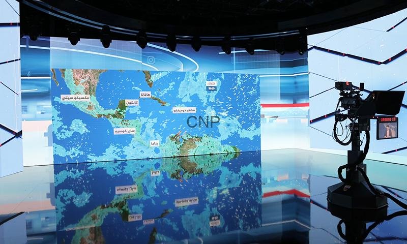 Television news studio with a large blue map screen showing 'CNP' and a professional camera on the right.