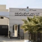 Front view of a government licensing department building with Arabic and English signage, gated entrance, and palm trees nearby.