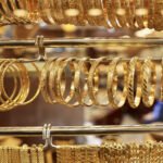 Rows of gold bangles and bracelets on display in a jewelry shop