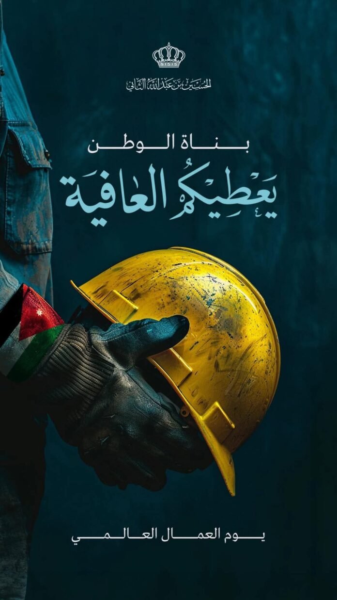 Worker in gloves holding a yellow hard hat against a dark teal background with Arabic poster text about World Day for Safety and Health at Work.
