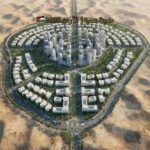 Aerial view of a scale model of a circular planned city with a dense central core and surrounding ring of buildings in a desert landscape.