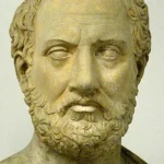 Marble bust of Aristotle, the ancient Greek philosopher, with a full beard and wavy hair facing forward.