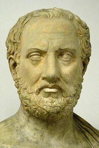 Marble bust of Aristotle, the ancient Greek philosopher, with a full beard and wavy hair facing forward.