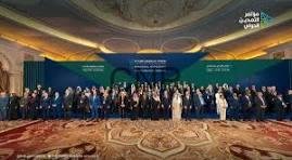daw - Center News Network Large group photo of conference attendees in formal attire on a stage in a grand hall, with a blue banner behind them.