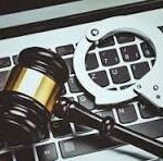 Gavel and handcuffs on a laptop keyboard, symbolizing legal action against cybercrime or tech-related crime.