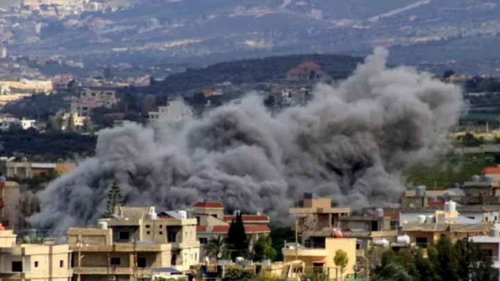 - Center News Network A large dark smoke plume rises over a residential neighborhood, suggesting an explosion or bombing in progress.