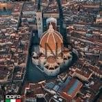 flo - Center News Network Aerial view of a domed church on an island, orange-tiled dome, linked to a dense city by bridges.