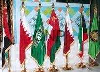 Row of colorful flags from different countries and organizations on gold poles displayed at a formal ceremony.