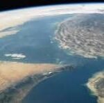 Satellite view of Earth from space with the letters CNP over a coastal region near the horizon.