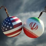 Two chained spheres painted with the US flag and the Iranian flag against a cloudy sky, symbolizing US–Iran ties or tension.