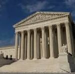 U.S. Supreme Court building with tall white columns and a triangular pediment on a sunny day.