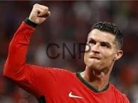 rona - Center News Network Soccer player in a red jersey raising a clenched fist in celebration on the field.