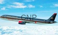 Passenger jet in flight above clouds, dark fuselage with red engine nacelles against a blue sky.