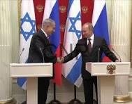 ruis - Center News Network Two male political leaders shake hands at a formal press conference, standing at podiums with Israeli and other national flags behind them.