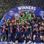 Sports team celebrating a championship on a podium with a blue 'WINNERS' arch and confetti scattered around.