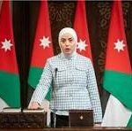 Woman at a podium giving an official briefing, with Jordanian flags behind her.