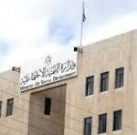 Front view of a beige multi-story government building with a flagpole and 'CNP' signage on the roof.
