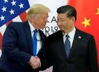 Donald Trump and Xi Jinping shake hands at a U.S.–China meeting, with American and Chinese flags in the background.