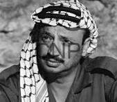 yaser - Center News Network Black-and-white portrait of a man wearing a checkered headscarf and dark shirt, looking to the left.