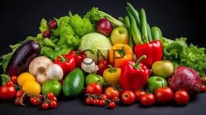 - Center News Network Assortment of fresh vegetables and fruits on a dark background, including peppers, tomatoes, cucumbers, lettuce, onions, cabbage, and broccoli.