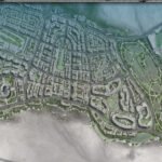Aerial view of a coastal city with dense streets and a large golf course to the east.