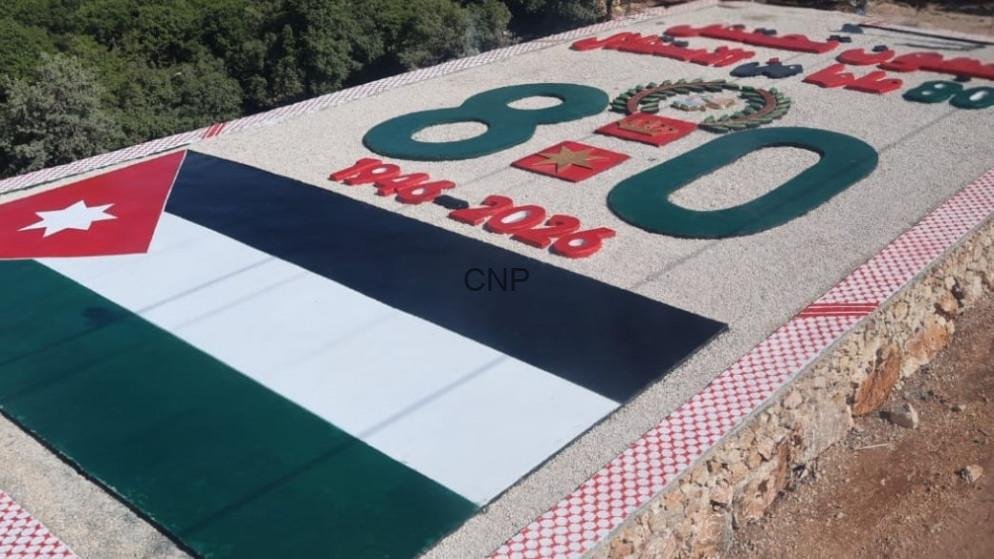 ajfos - Center News Network Outdoor memorial slab featuring the Jordan flag, large green numerals, and a red-and-white patterned border on a gravel surface.