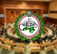 Emblem of the Afghan Parliament centered on a blurred parliamentary chamber background.