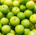 Close-up of fresh green limes piled together in a basket or pile.