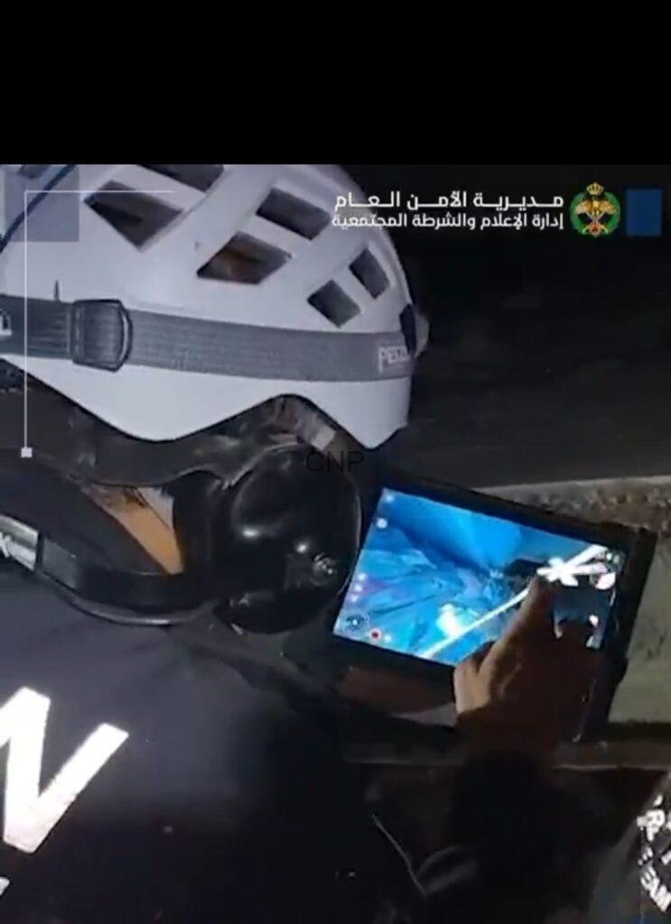 fanz2 - Center News Network Police officer wearing a protective helmet at night while using a tablet.