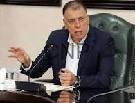 faray - Center News Network Man in a dark suit speaks into a microphone at a conference table, gesturing with his left hand.
