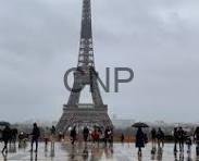 france - Center News Network Eiffel Tower centered in view with crowds of people on a damp plaza under gray, cloudy skies.