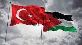 jotur - Center News Network Turkish flag and Palestinian flag waving together against a cloudy sky, symbolizing solidarity between Turkey and Palestine.