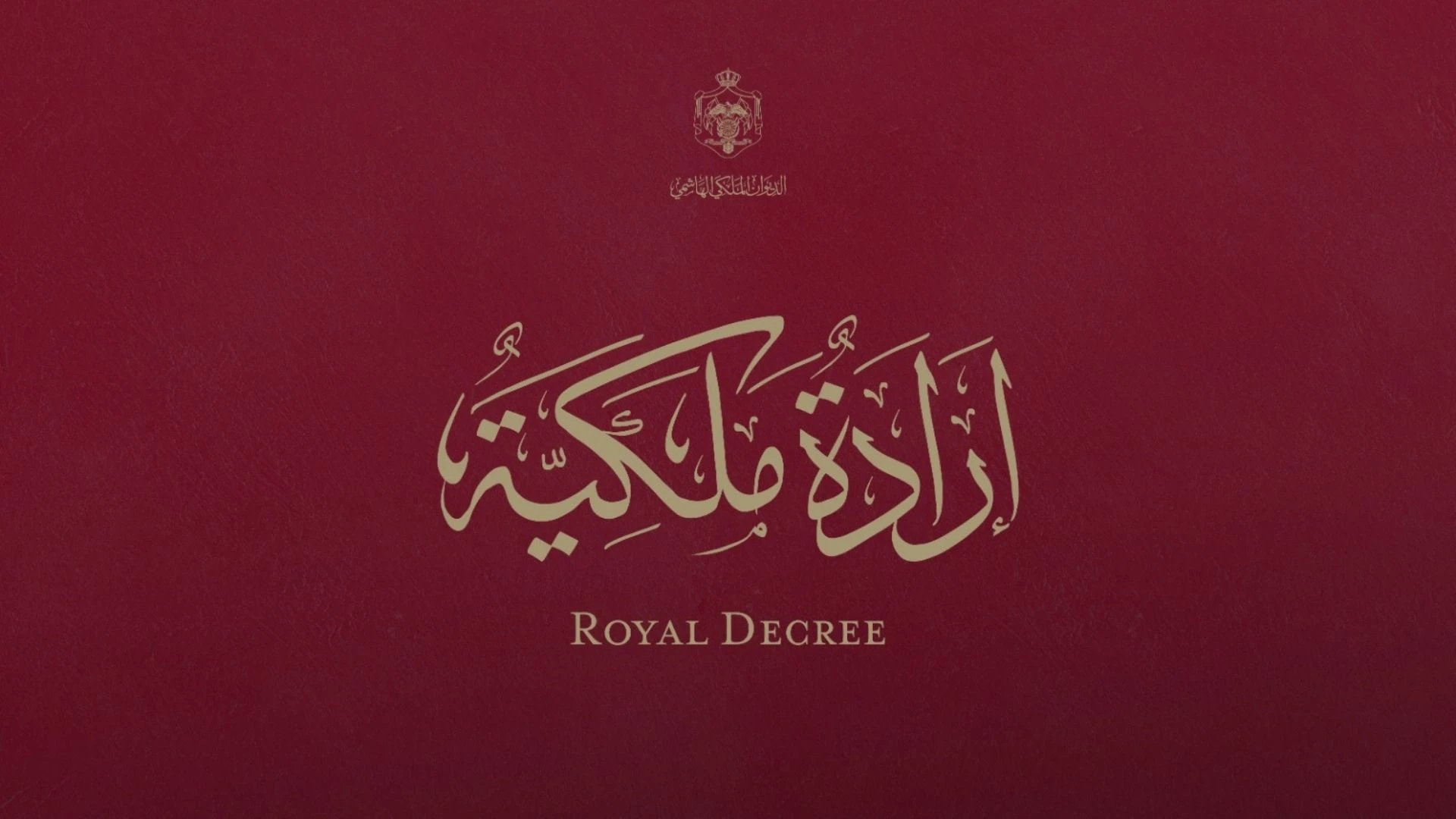 Red textured cover with gold Arabic calligraphy and a small crest, labeled 'Royal Decree' in English.