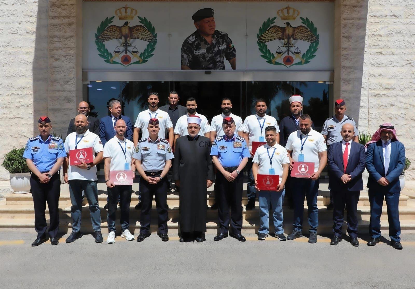 Group of uniformed officers and officials posing for a ceremony photo outside a building with emblems above the entrance.