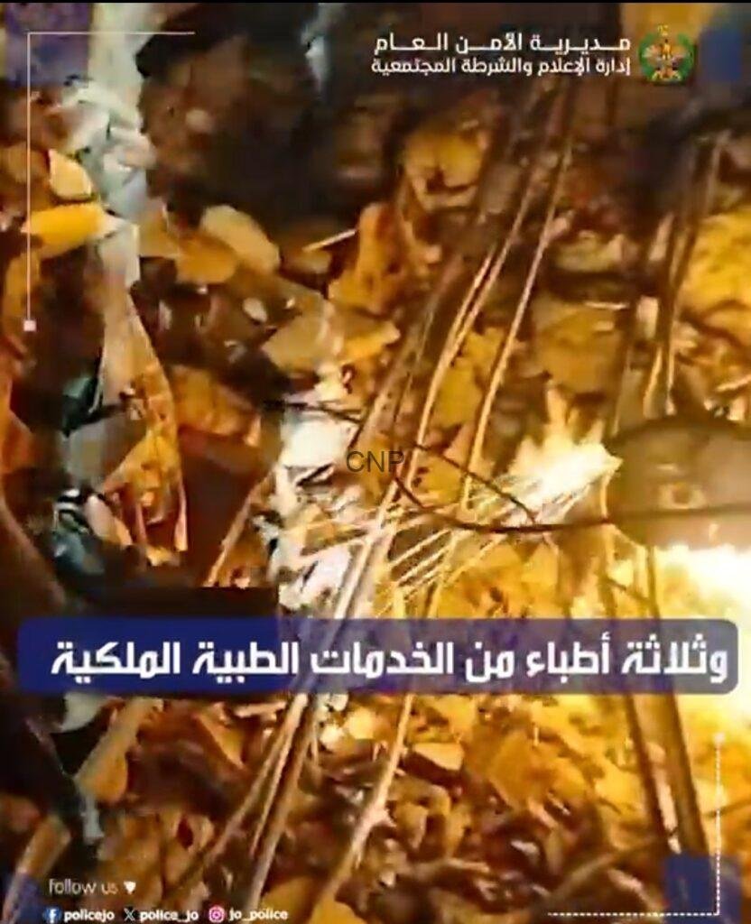 Nighttime scene of a collapsed building with rubble and wooden beams, with emergency responders working amid the debris; Arabic news caption overlay visible.