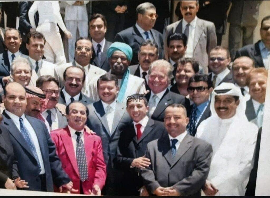 sss33 - Center News Network Large group of men in suits and traditional attire posing for a group photo on steps outdoors.