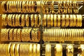 - Center News Network Stacked shelves of gold bangles and bracelets in a jewelry shop display case, varying in width and designs.