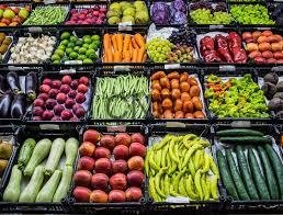 - Center News Network Assorted fresh fruits and vegetables displayed in market crates, organized in colorful rows.