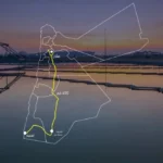 Map overlay of Oman with a highlighted yellow route running north-south, labeled 450 كم, on a sunset harbor photo