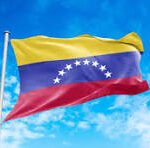 Venezuelan flag waving on a flagpole against a bright blue sky.